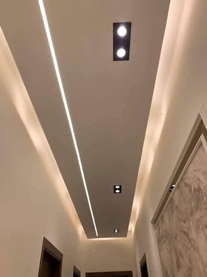 Couloir à faux plafond à lignes lumineuses LED et spots