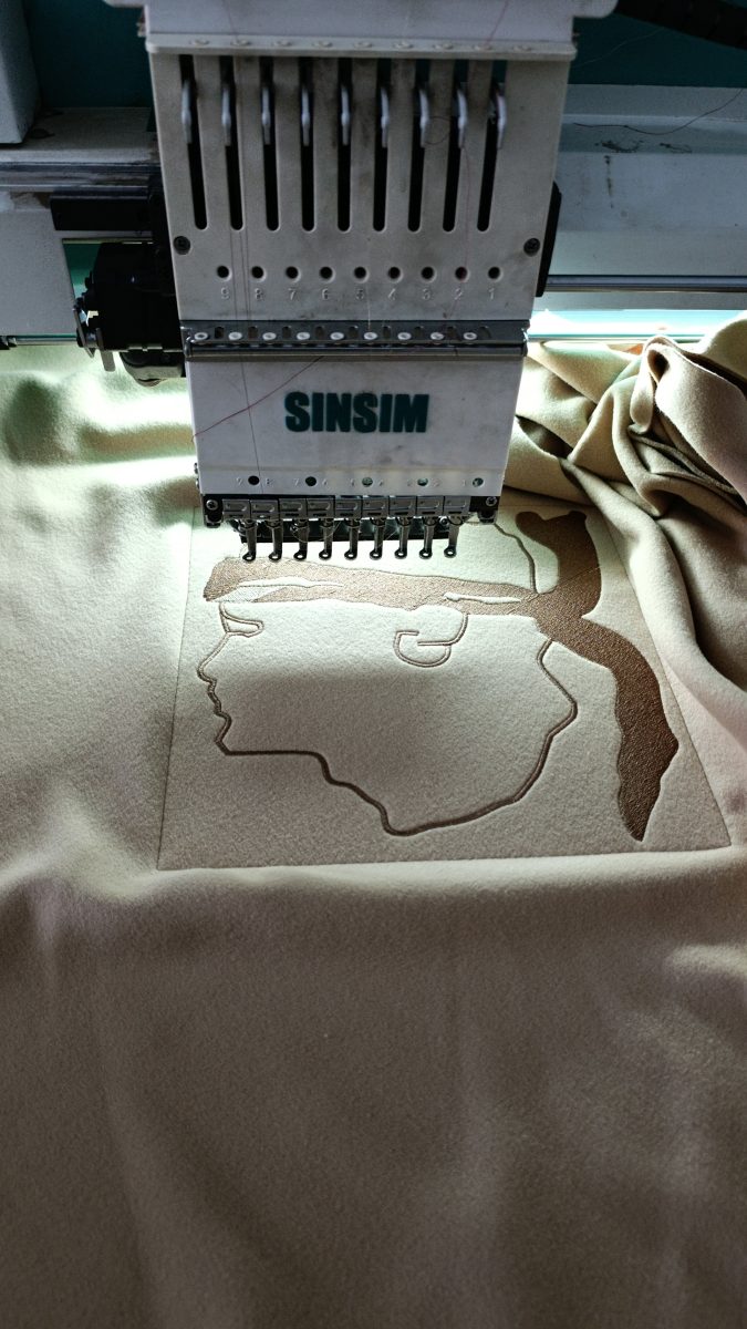 Machine à broder industrielle brodant un motif sur tissu