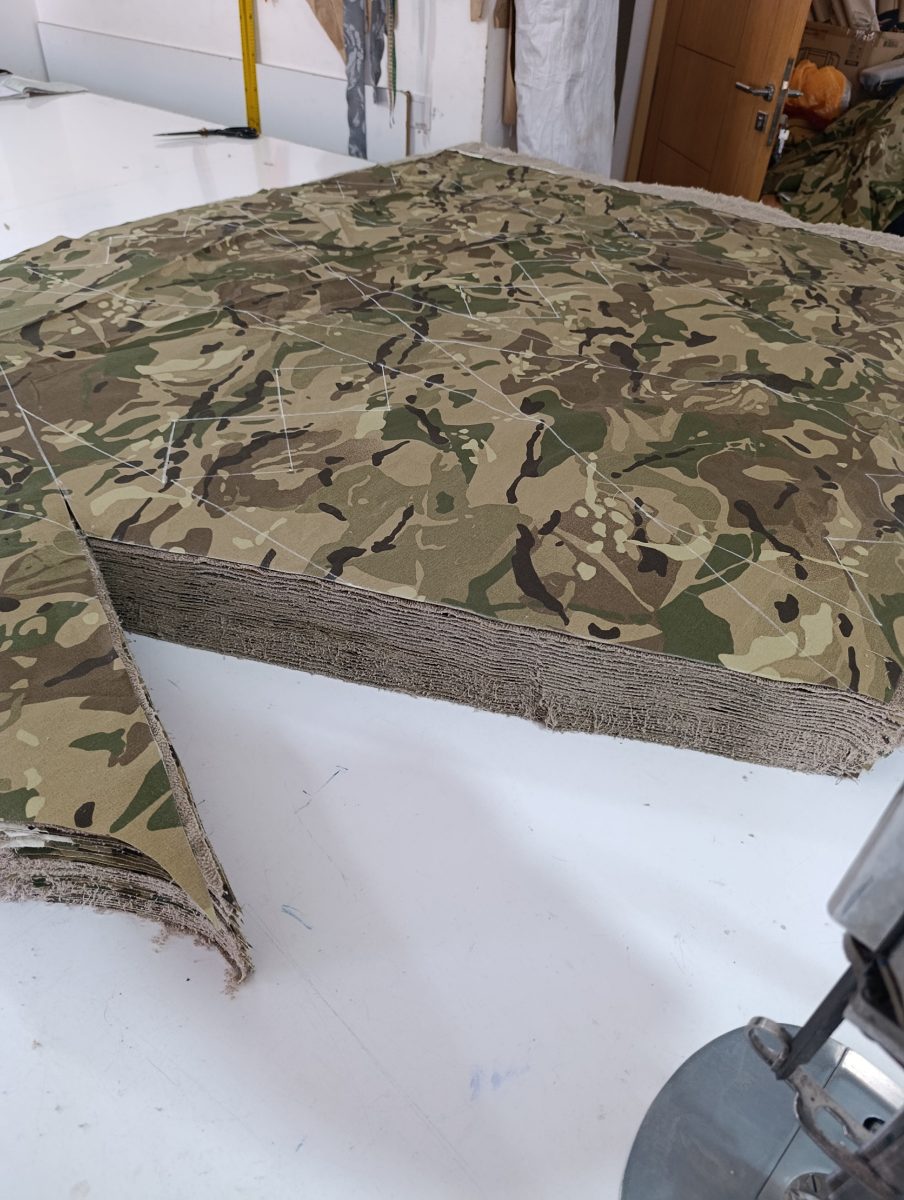 Matelas de tissu camouflage découpé sur table de coupe