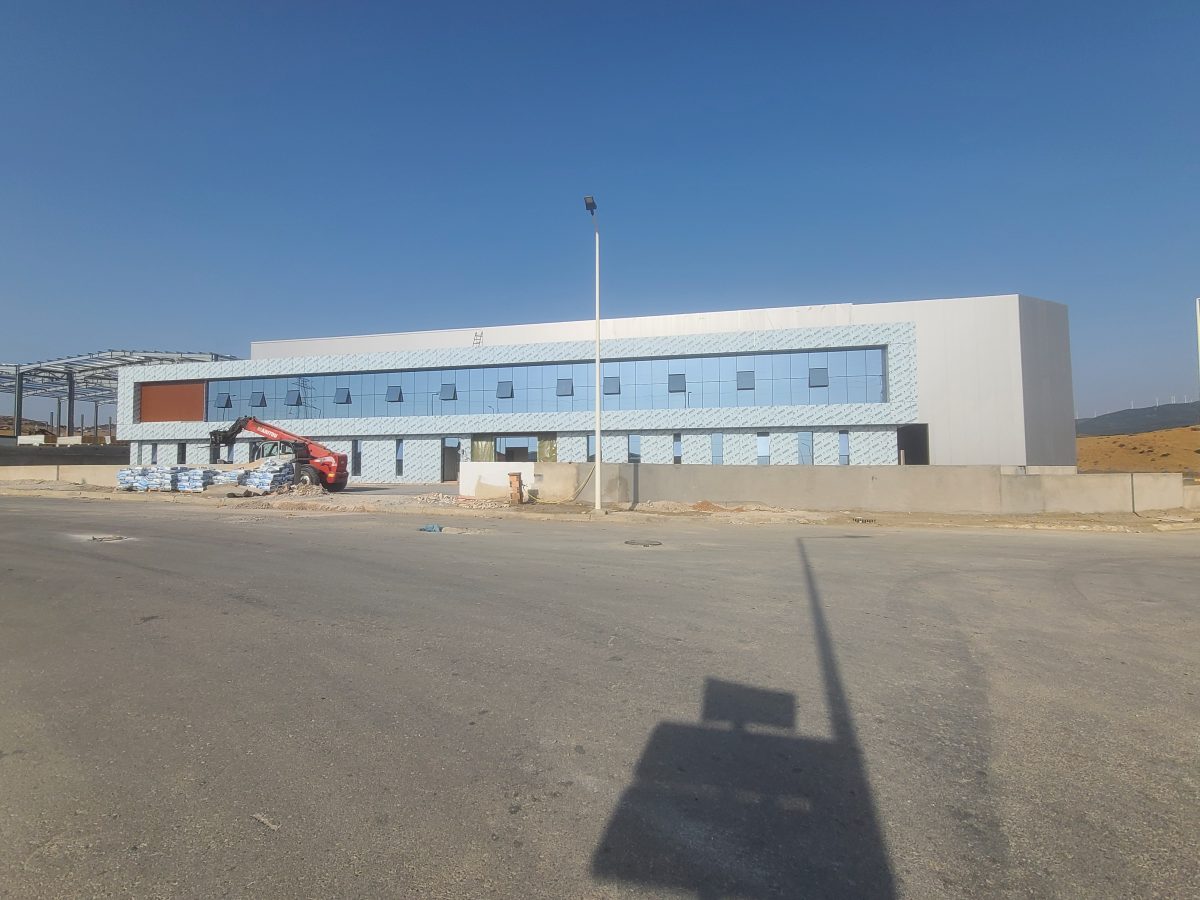 Façade de bâtiment en cladding bleu et mur-rideau vitré, en construction