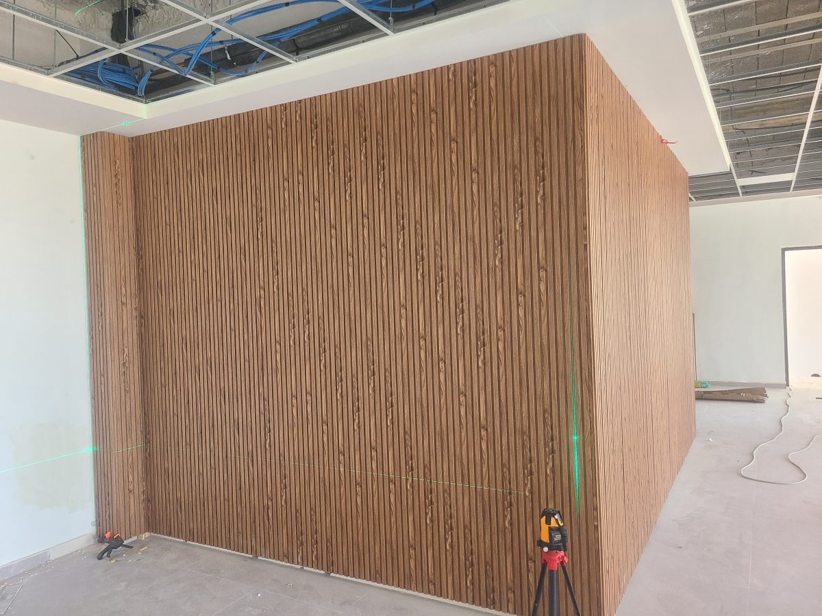 Volume habillé de tasseaux de bois effet noyer, en cours