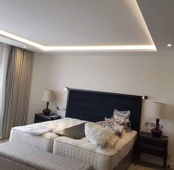Chambre à faux plafond à gorge lumineuse LED et lit capitonné