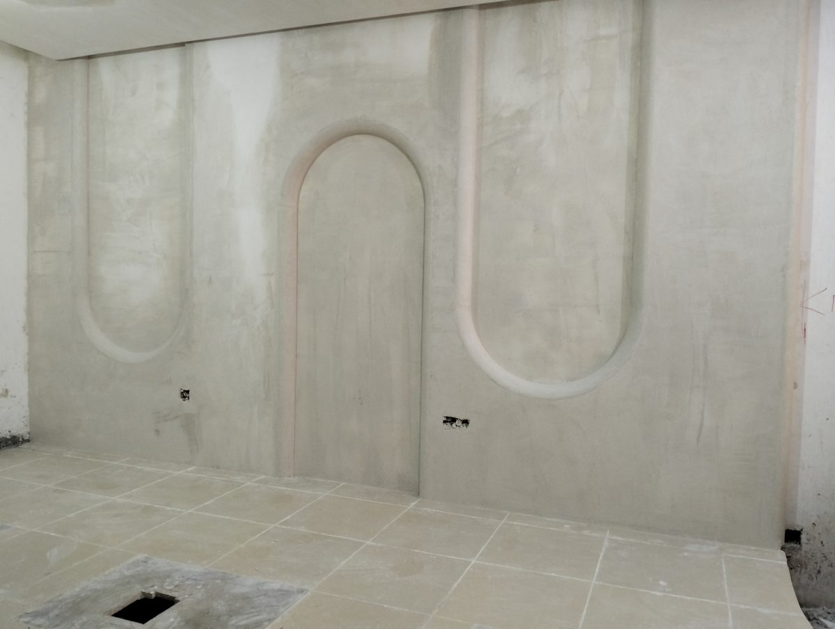Mur en plâtre à arches et niches ovales en relief, en cours