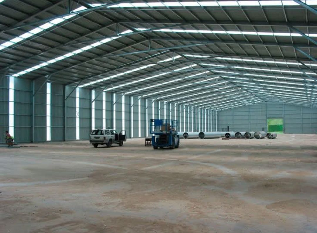 Intérieur d'un grand hangar industriel à charpente métallique