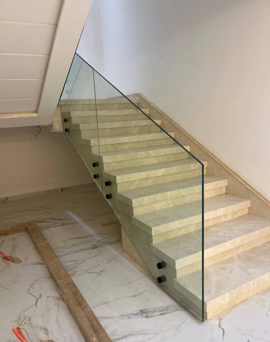 Escalier en marbre à garde-corps en fer forgé noir épuré