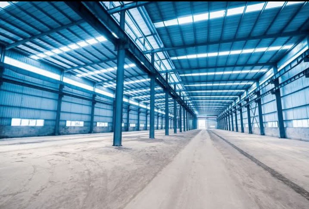 Intérieur d'un grand hangar à charpente métallique