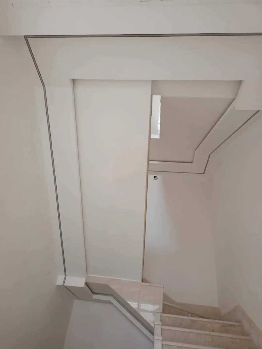 Cage d'escalier habillée en plâtre à filets et moulures