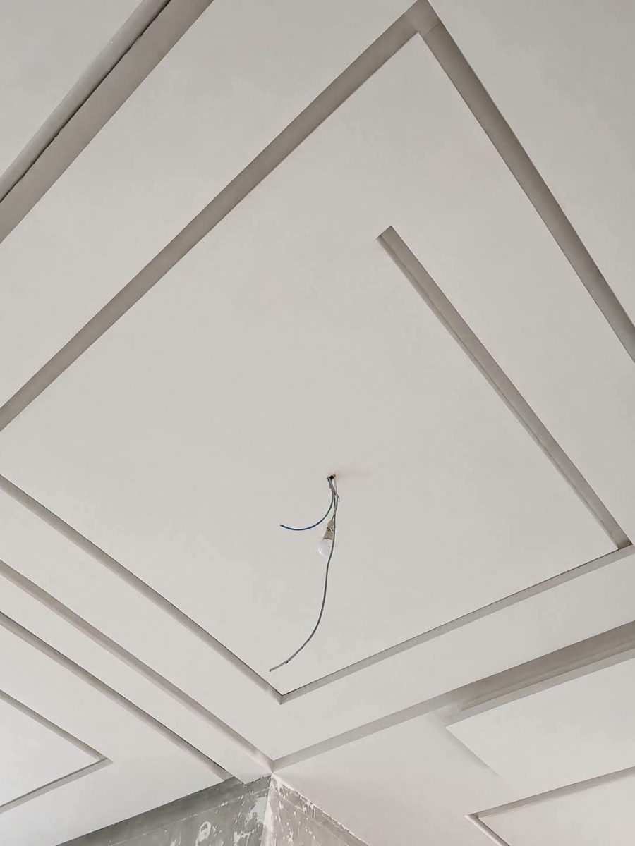Faux plafond blanc à cadres concentriques en losange, en cours