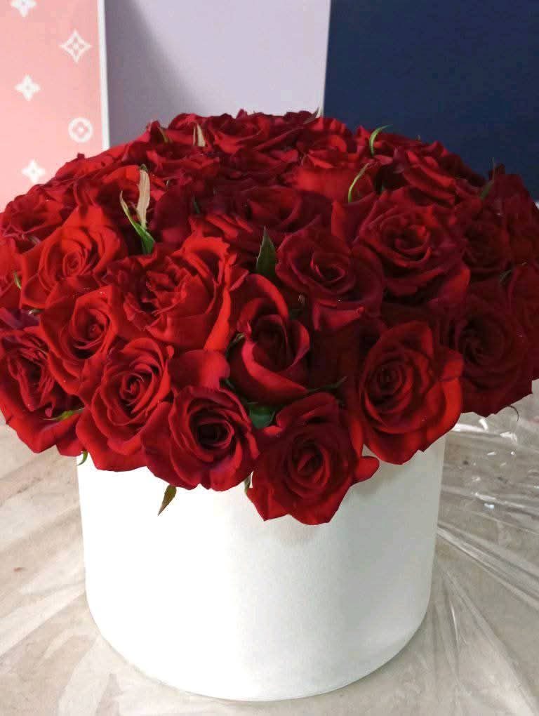 Box rond blanc de roses rouges serrées
