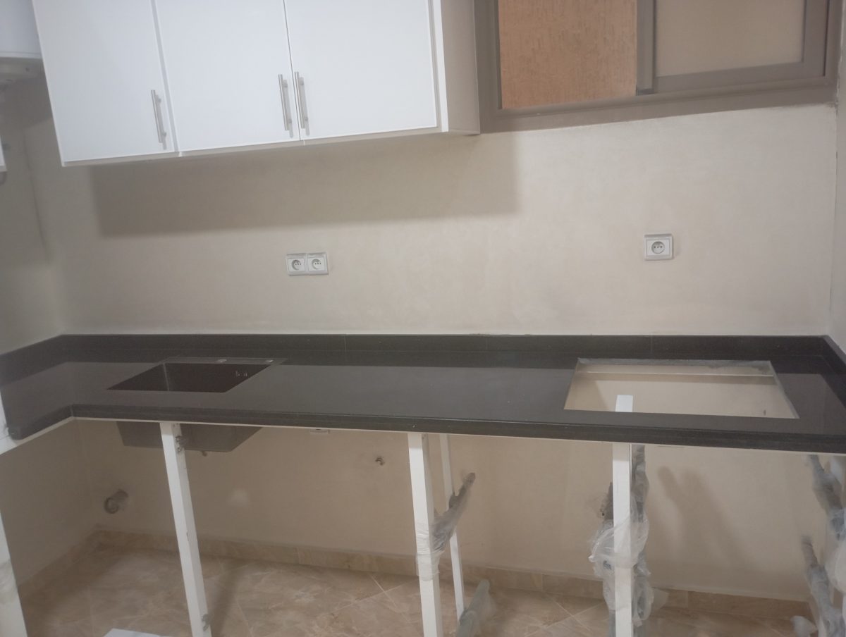 Plan de cuisine en granit noir sous meubles hauts