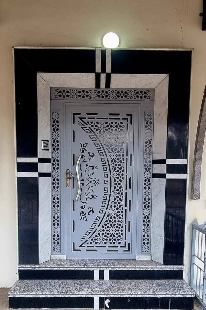 Porte d'entrée en acier gris à panneaux découpés zellige