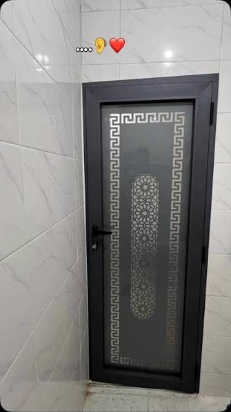 Porte en aluminium noir à verre fumé et bande ajourée zellige