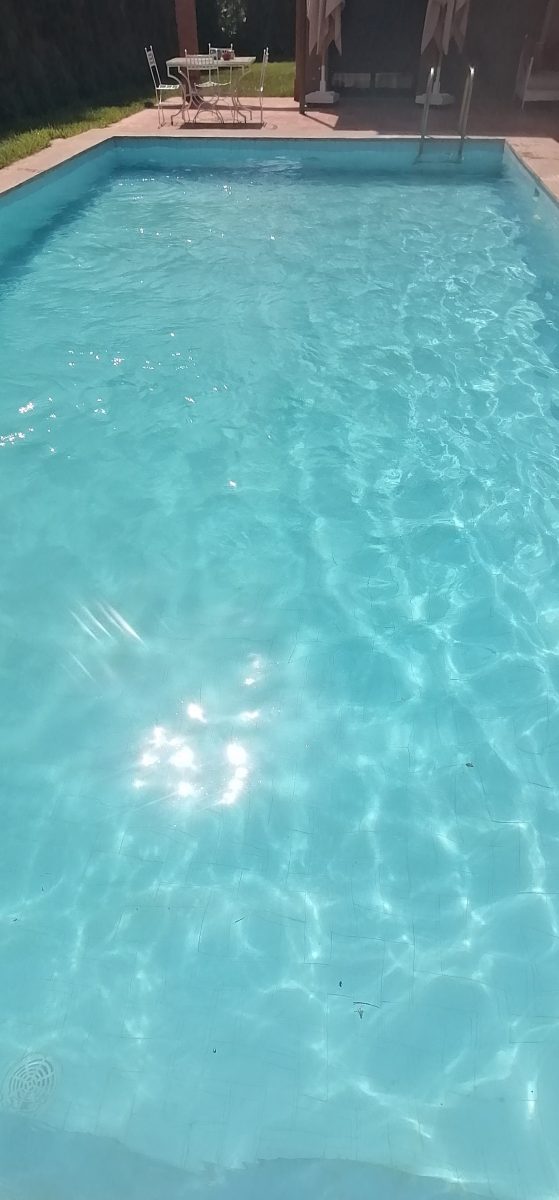 Piscine à eau turquoise claire à carrelage clair