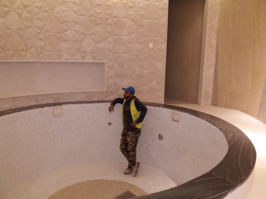 Bain rond en mosaïque blanche à margelle marbre noir