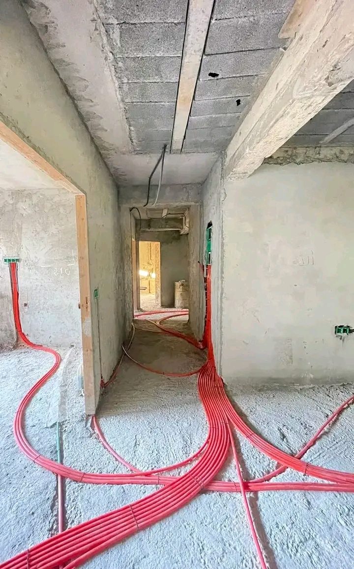 Passage de gaines électriques rouges dans un appartement