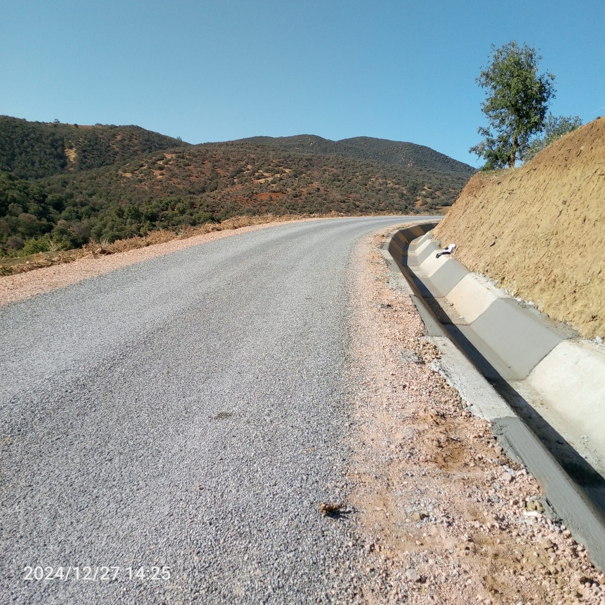 Route de montagne revêtue avec caniveau en béton