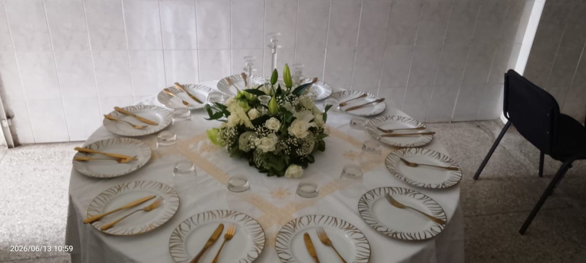 Table ronde de réception dressée à filet doré et centre floral