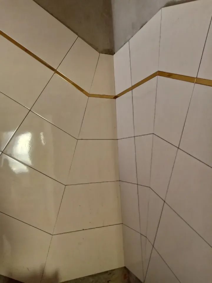 Angle de mur en faïence crème avec listel doré