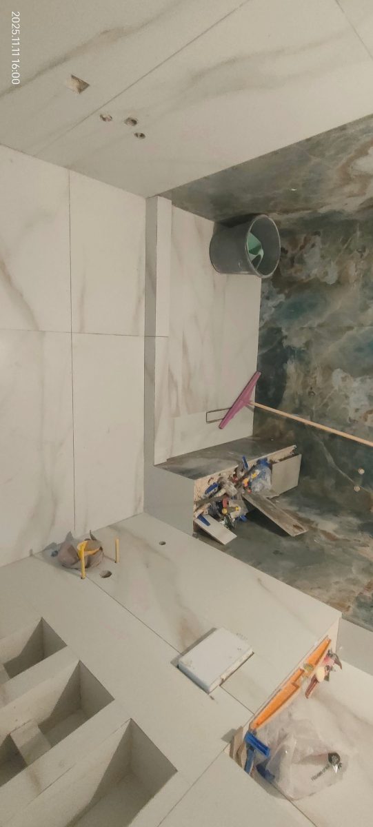 Salle de bain en faïence effet marbre blanc et vert, en cours
