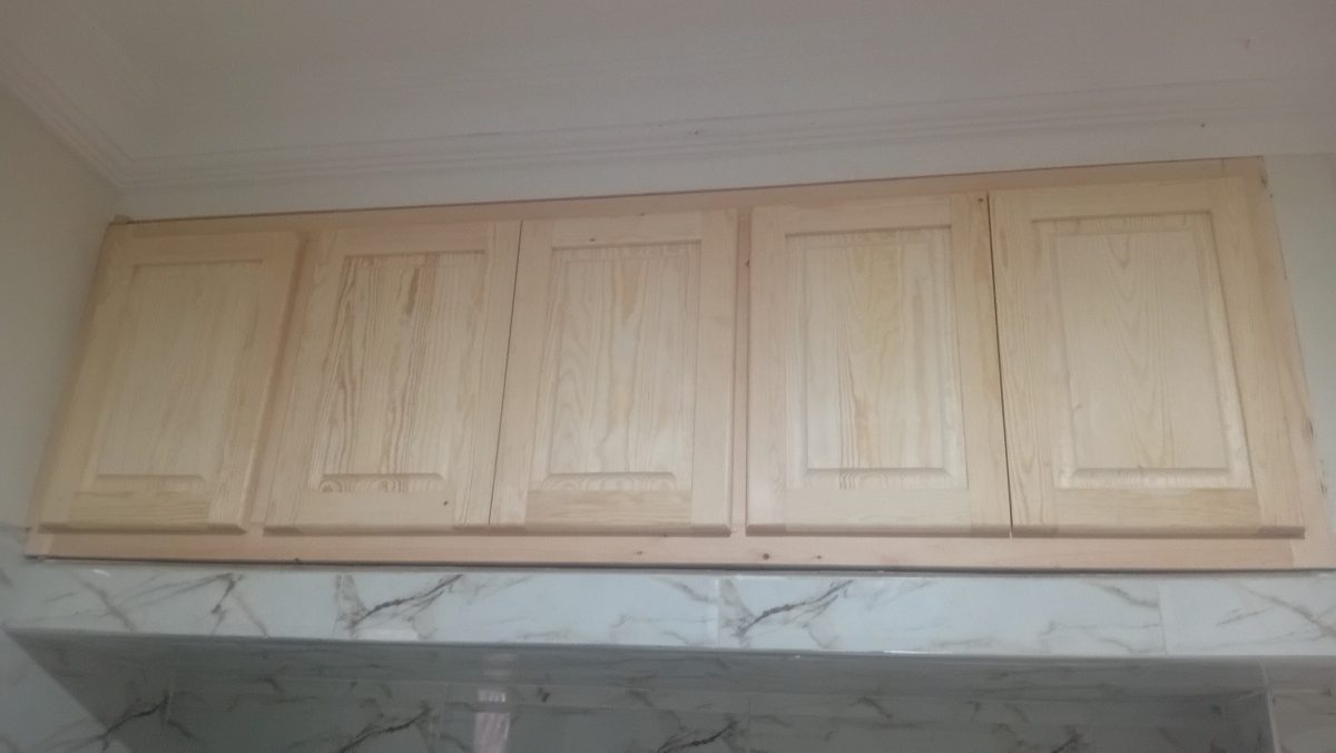 Meuble en bois de pin clair à panneaux moulures, en atelier