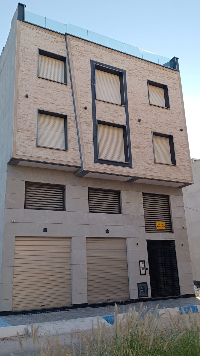 Immeuble à façade en pierre beige et garde-corps verre