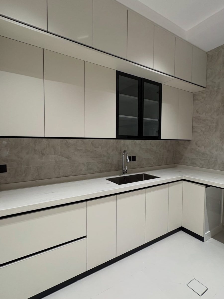 Cuisine en L crème à liseret noir et plan quartz blanc