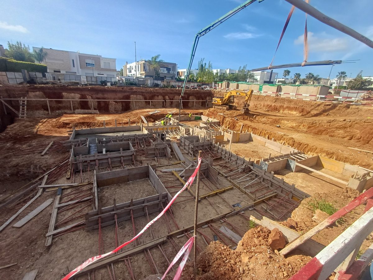 Chantier de fondations à semelles ferraillées et pompe à béton