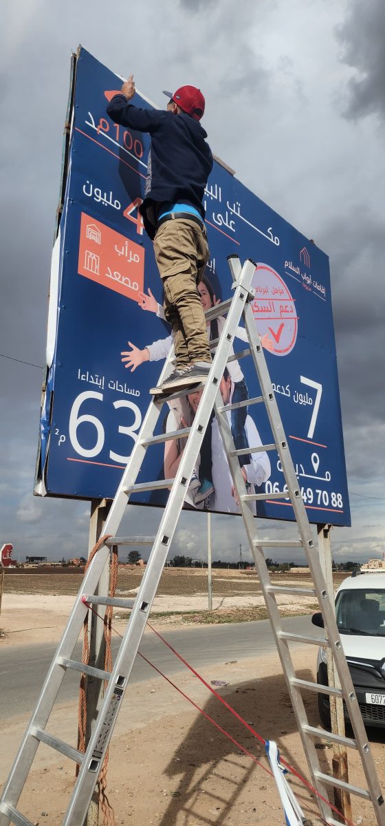 Pose de bâche sur panneau publicitaire