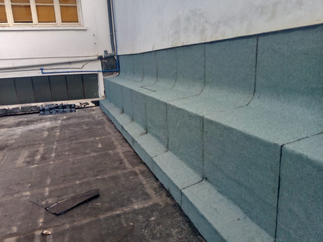 Relevé d'étanchéité vert au pied d'un mur