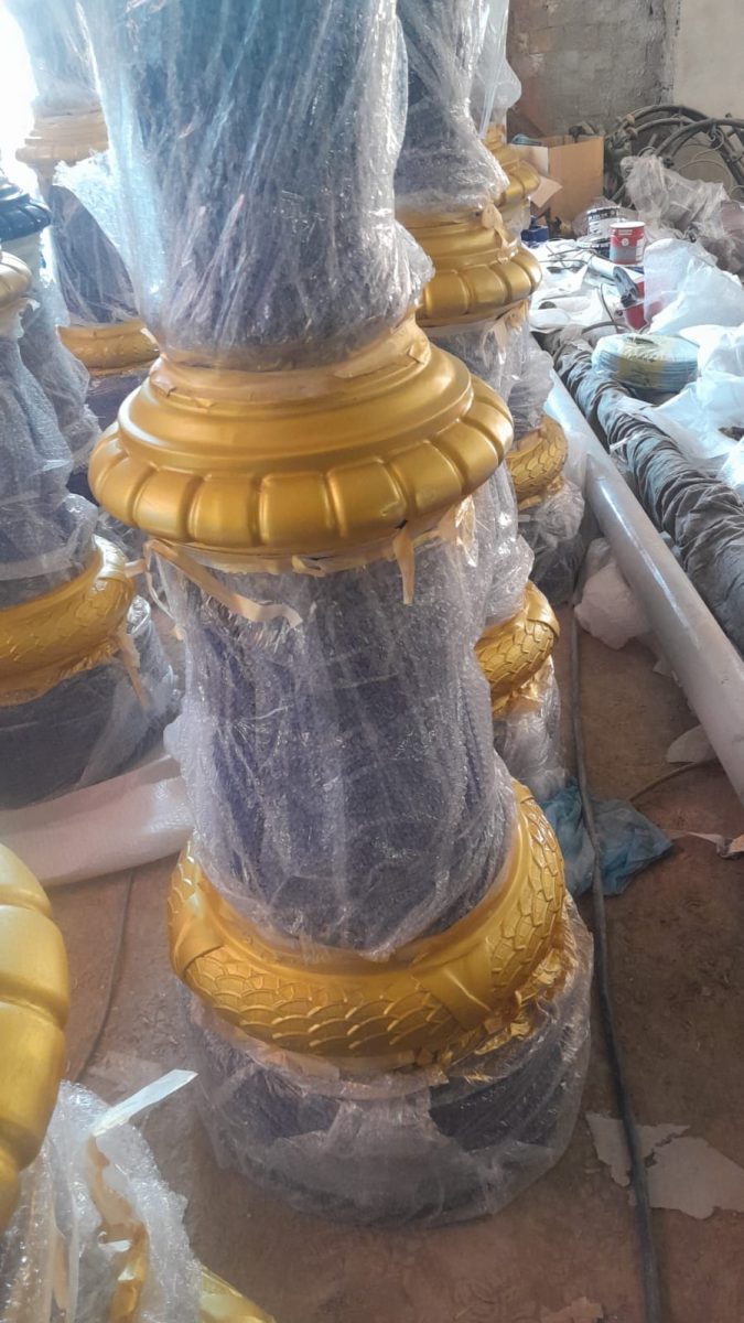 Colonnes d'éclairage à fut gris et bagues dorées, en atelier