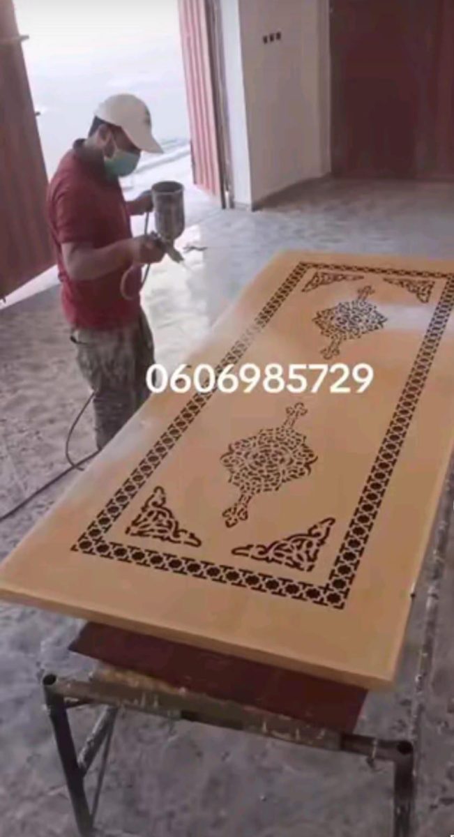 Peinture au pistolet d'une porte à pochoir arabesque