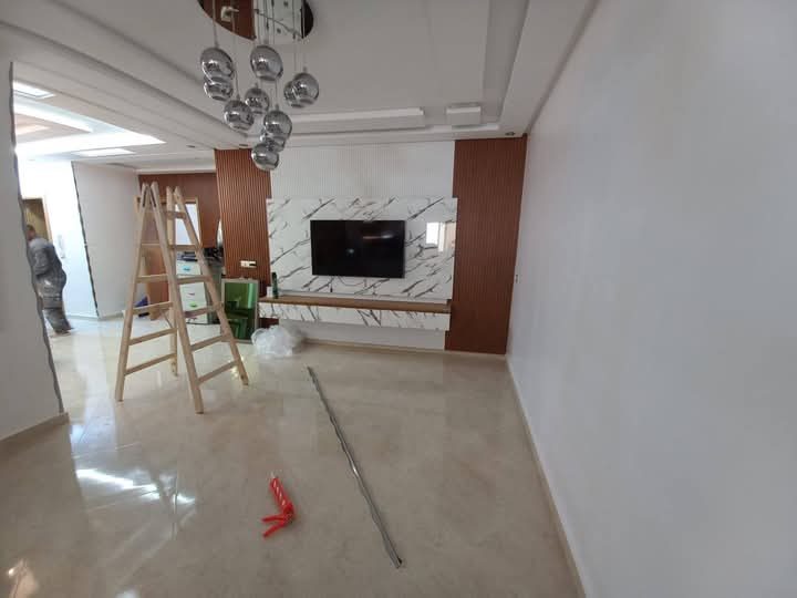 Séjour à mur TV effet marbre et lambris bois, en cours