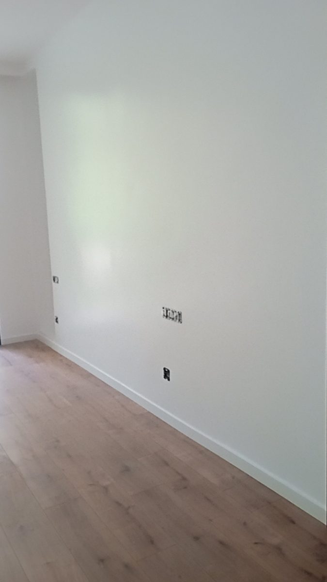 Pièce peinte en blanc à parquet clair a Sale