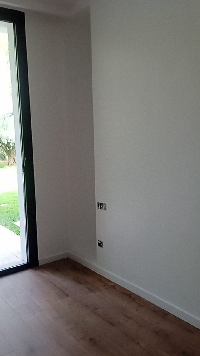 Pièce peinte en blanc avec baie sur jardin a Sale