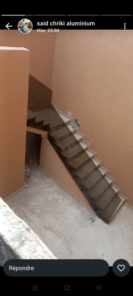 Cage d'escalier à paroi en verre fumé et escalier béton