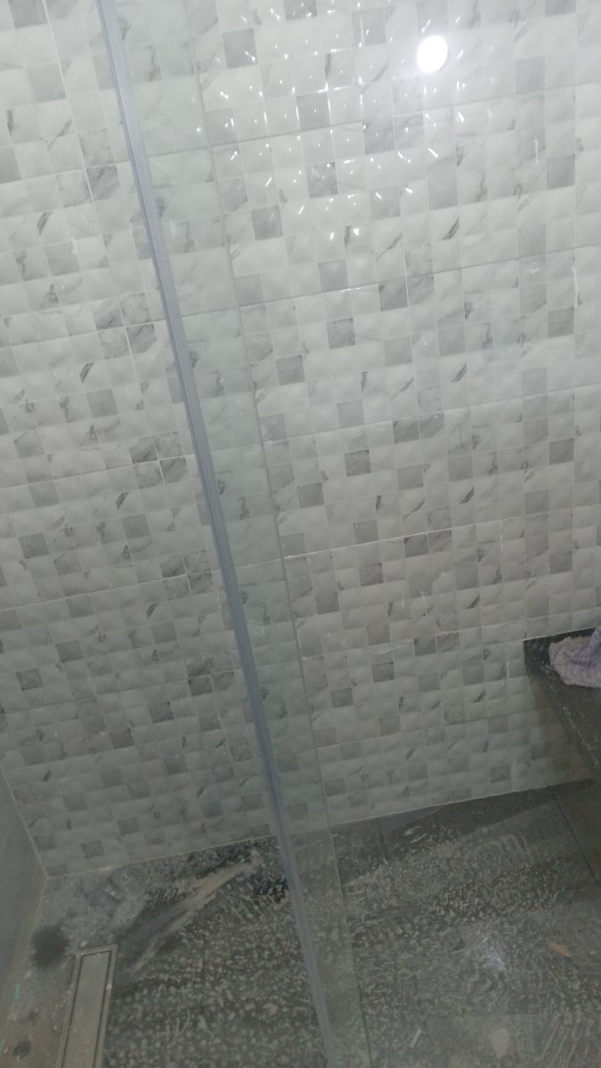 Paroi de douche en verre dans une salle de bain effet marbre