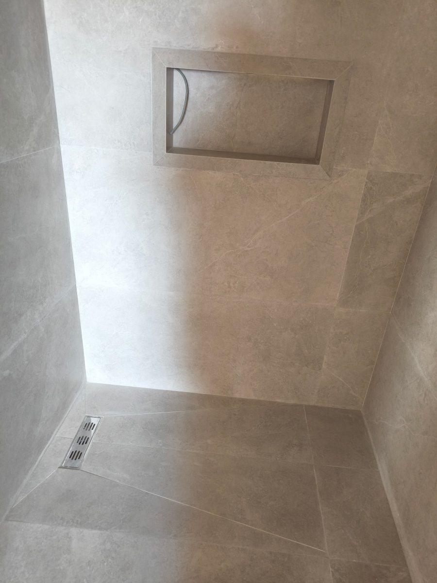 Douche en grands carreaux effet marbre beige à niche
