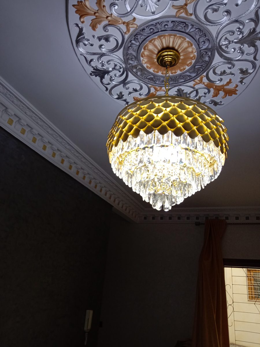 Plafond à rosace en plâtre argent et or et lustre à pampilles