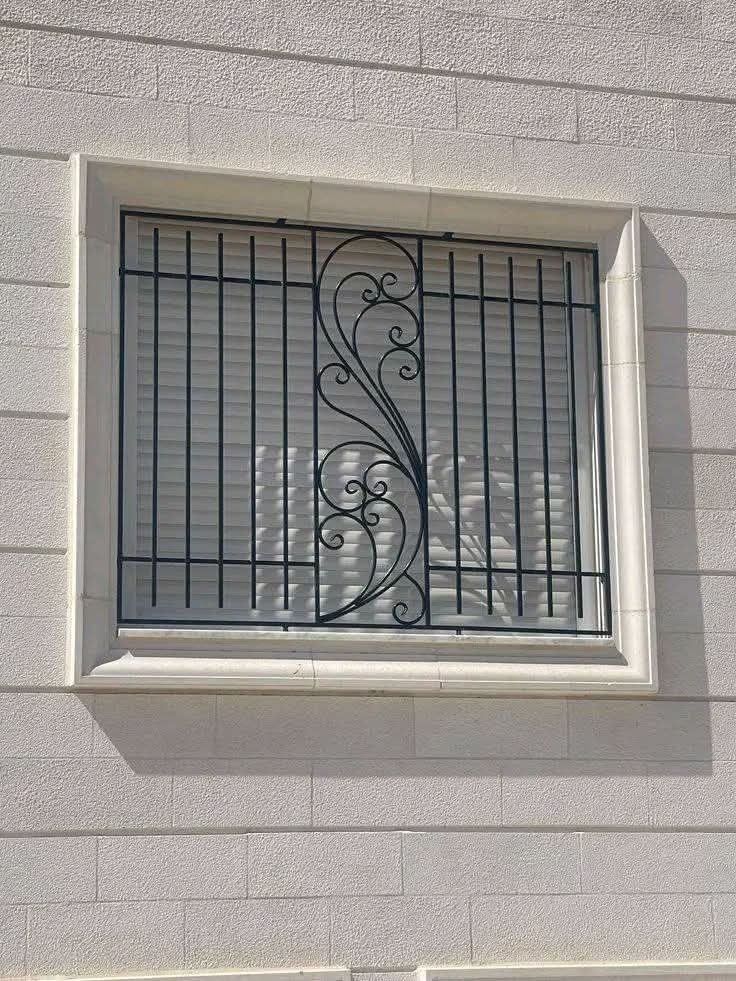 Grille de fenêtre en fer forgé noir à volute centrale