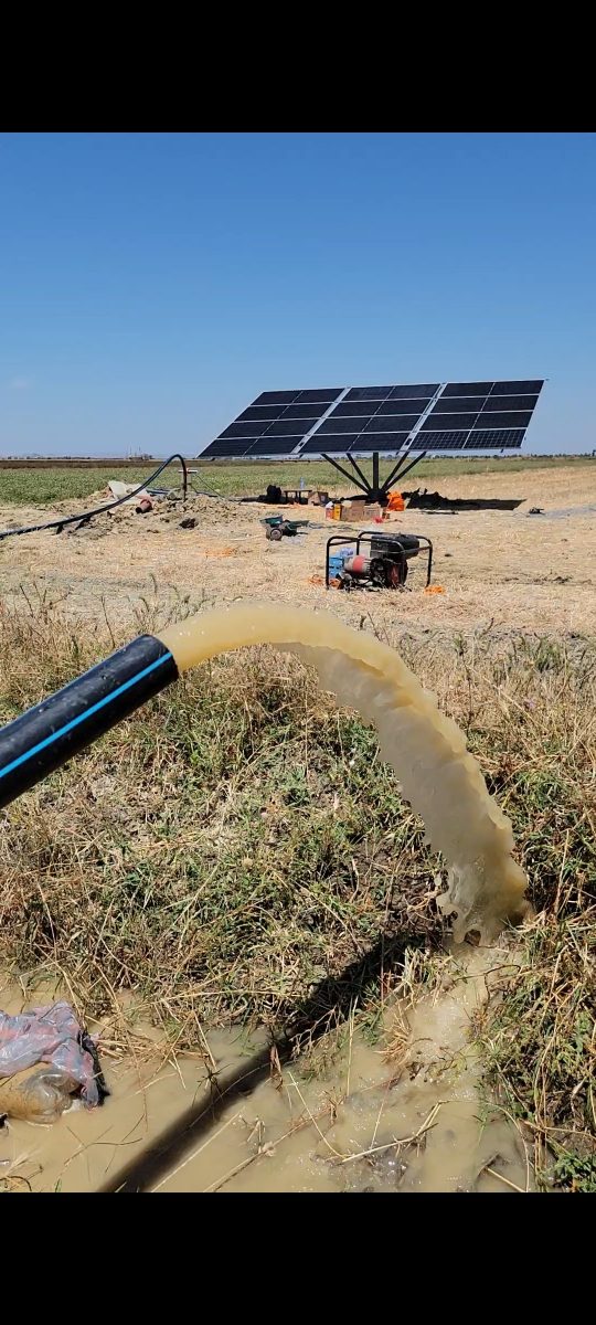 Pompage solaire déversant l'eau dans un champ
