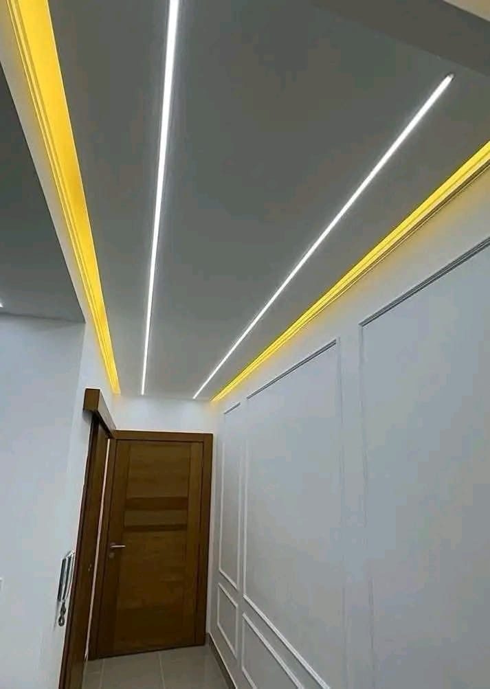 Couloir à faux plafond à rubans lumineux et moulures