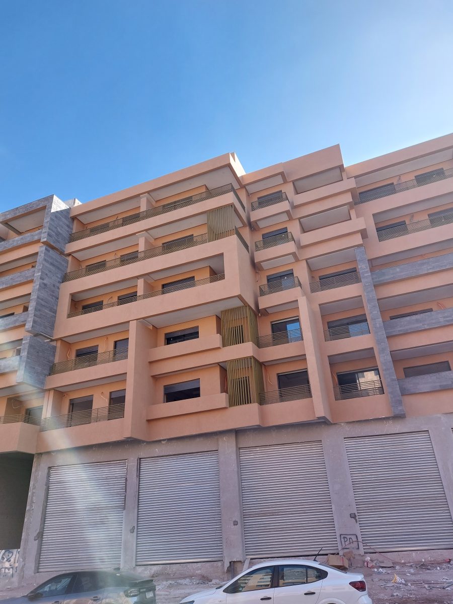Façade d'immeuble peinte en saumon à balcons