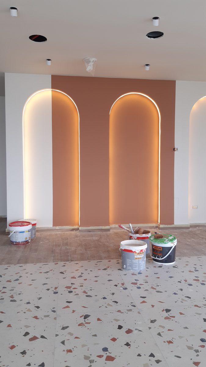 Niches en arc rétro-éclairées sur mur terracotta