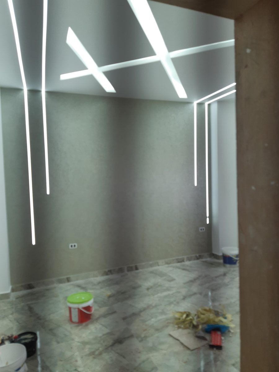 Pièce à faux plafond à lignes LED et enduit gris