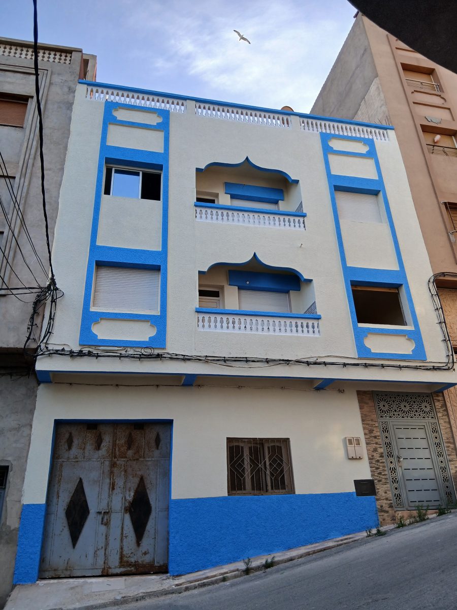 Façade peinte en crème et bleu à arcs décoratifs