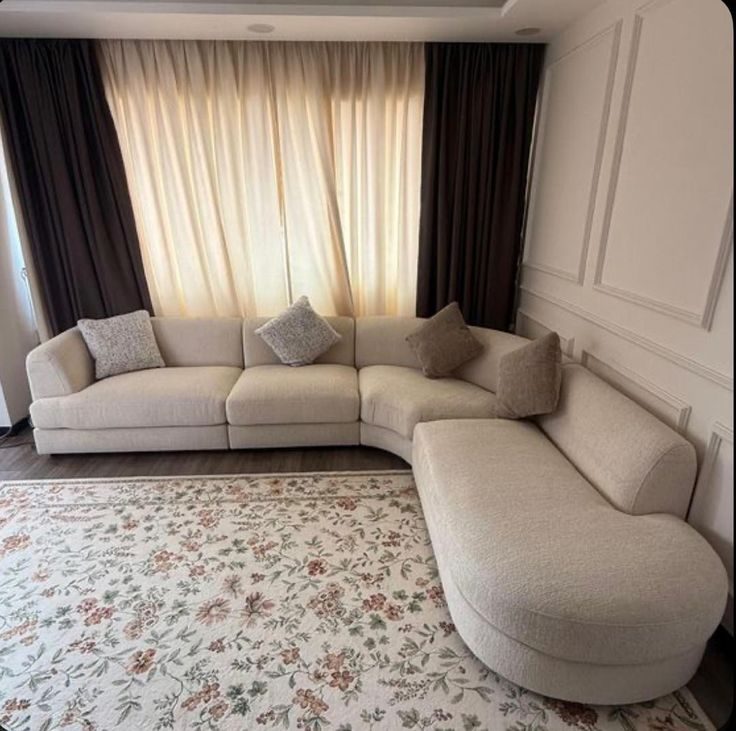 Canapé d'angle courbe beige sur tapis fleuri