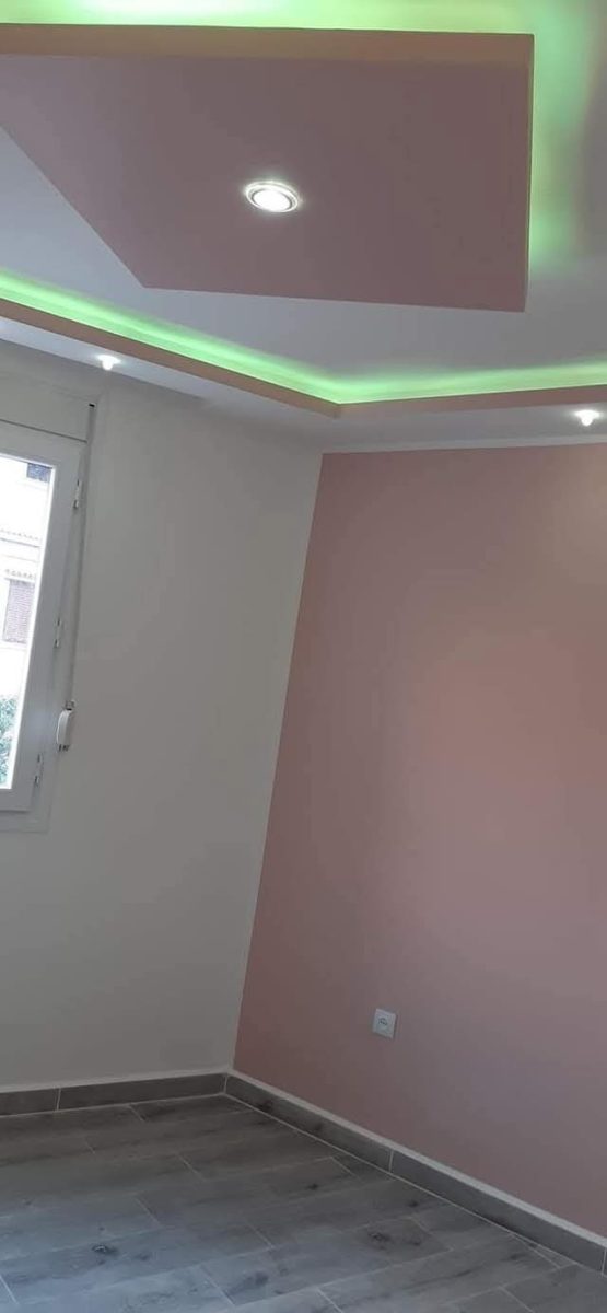 Chambre à mur rose et faux plafond LED vert