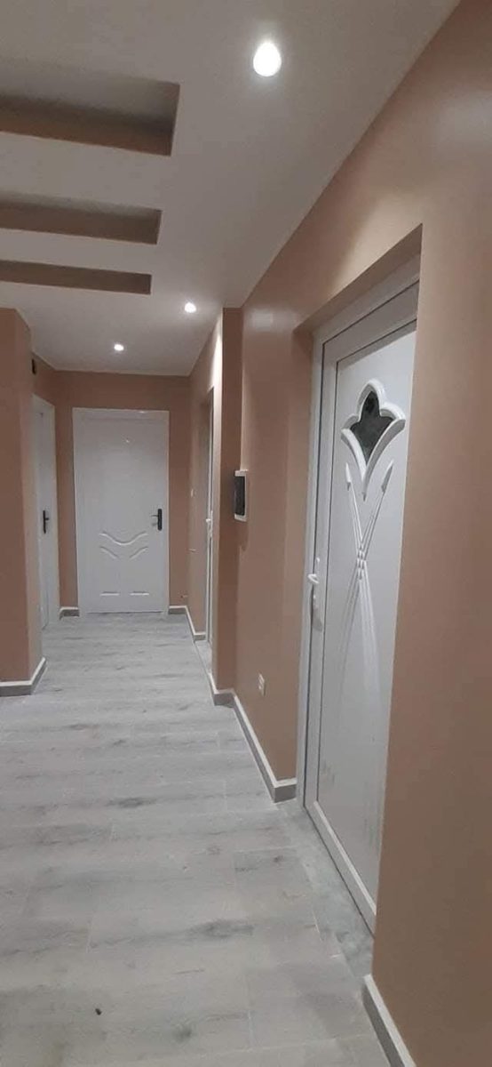 Couloir peint en tons taupe à portes blanches