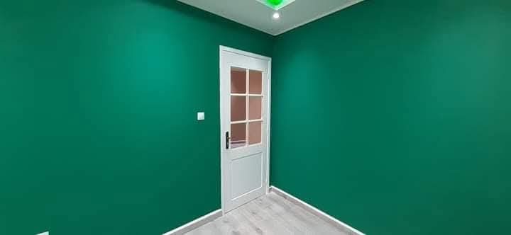 Pièce peinte en vert profond à porte blanche