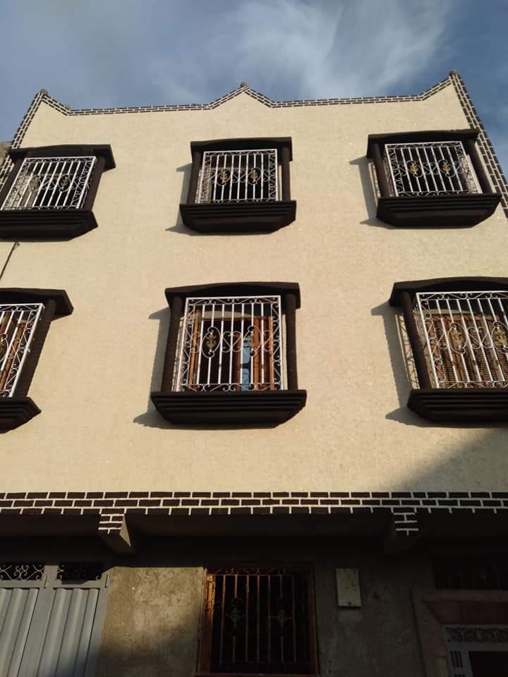 Façade en enduit texturé à bandeaux de brique